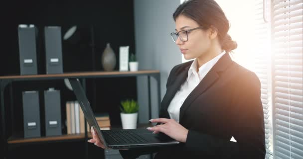 Mujer de negocios con anteojos usando laptop — Vídeos de Stock