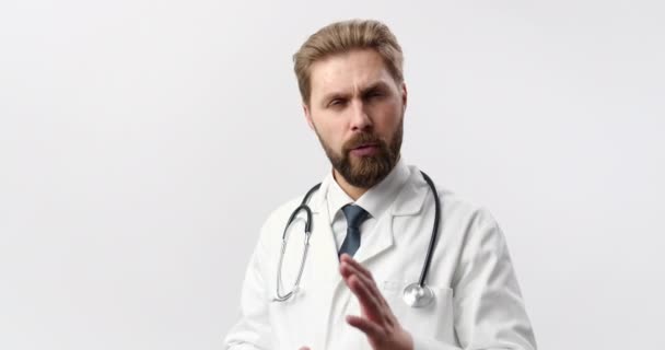 Doutor em jaleco falando enquanto posando em estúdio — Vídeo de Stock
