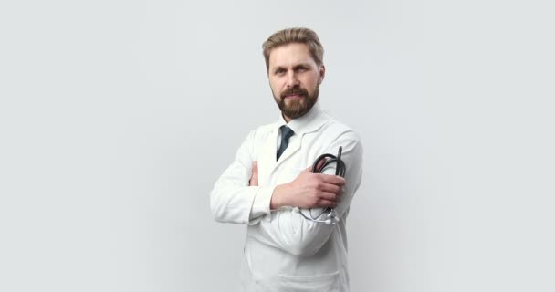 Front view of smiling doctor in lab coat holding stethoscope — 비디오