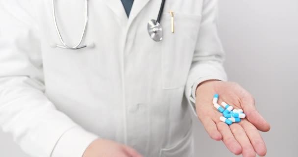 Close up de médico masculino segurando lotes de comprimidos em uma mão — Vídeo de Stock