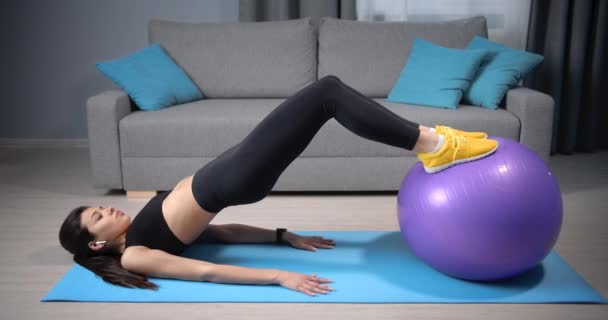 Красивая леди упражняется дома на фитнес-мяч — стоковое видео