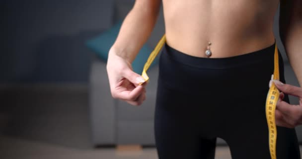 Woman with slender body measuring waist with tape — Stok video