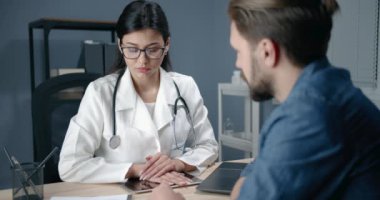 Kadın doktor hastayla konuşuyor.