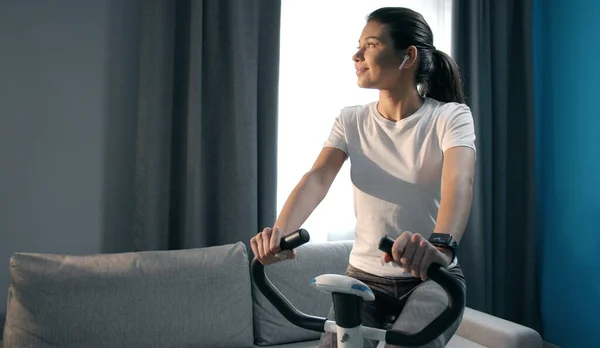 Sporty lady on cycling machine