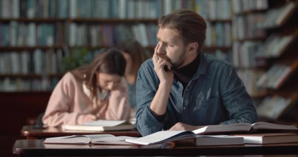 Hombre Barbudo Estudiando en la Biblioteca — Vídeos de Stock