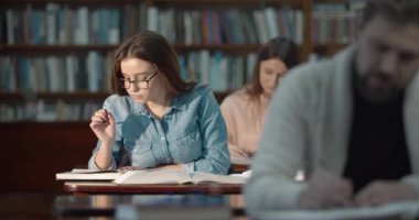 Kütüphanede okuyan genç kız öğrenci