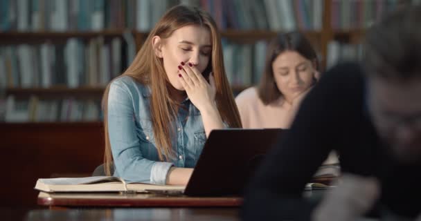 Müde Studentin in der Bibliothek — Stockvideo