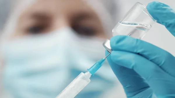 Medical person filling syringe close-up