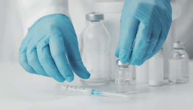 Hands taking syringe and vial