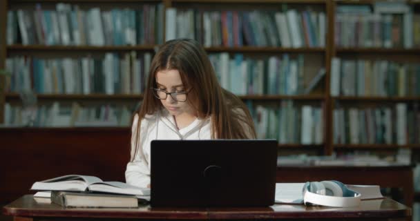 Female Student with Laptop Reading in Library — Stock Video