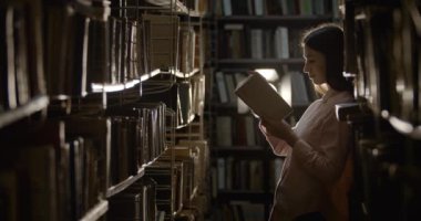 Woman with Book in Dark Library
