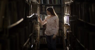Woman Searching Book in Dark Library