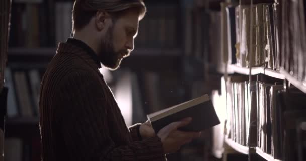 Bearded Man Reading Dusty Book in Library — Stockvideo