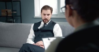 Back view of female psychologist listening bearded patient
