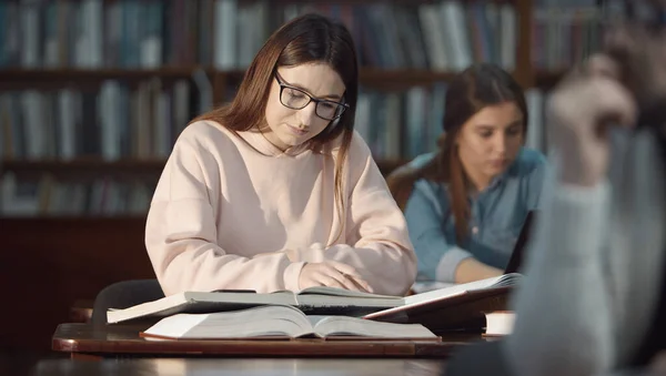 Dziewczyna studiuje w bibliotece — Zdjęcie stockowe