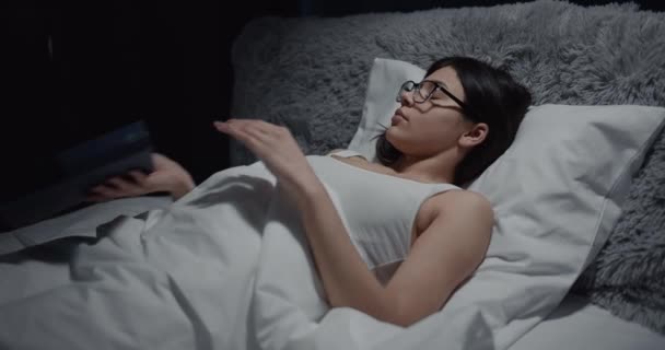 Женщина заканчивает читать книгу в постели — стоковое видео