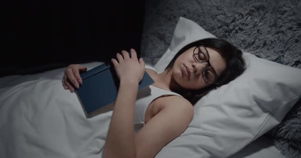 Frau schläft mit Buch im Bett — Stockvideo