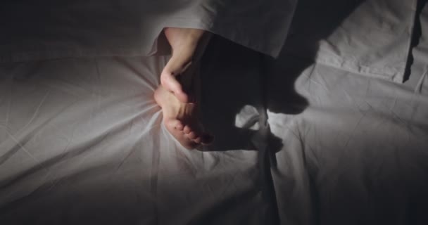 Vrouwelijke voeten in bed op ochtend licht — Stockvideo