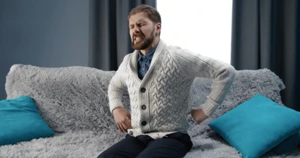 Hombre Sufriendo Dolor de Espina Sentado en un Sofá — Vídeos de Stock