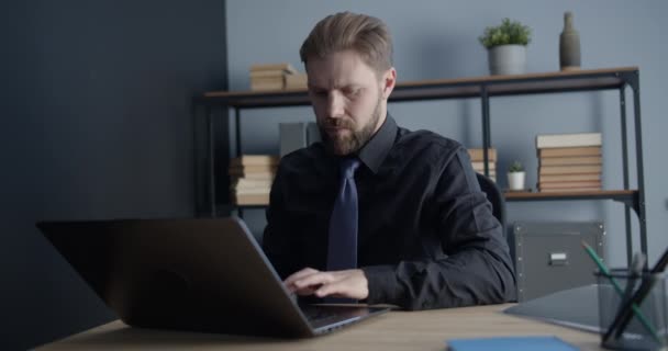 Человек, работающий над ноутбуком в офисе — стоковое видео