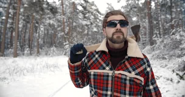 Professional lumberjack holding axe at snowy forest — Αρχείο Βίντεο