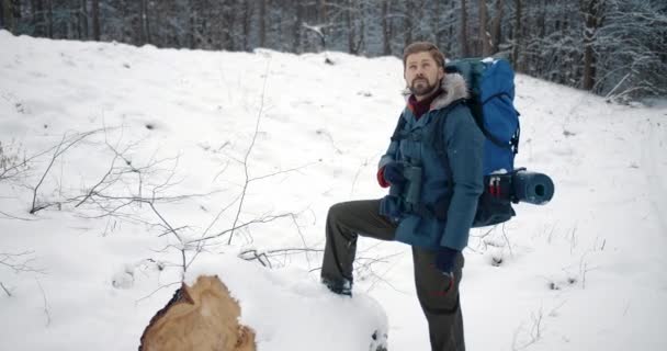 Homem barbudo olhando na natureza nevada através de binóculos — Vídeo de Stock