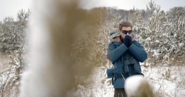 Vousatý turista se snaží zahřát ruce — Stock video