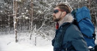 Sırt çantalı olgun turist, karlı doğanın tadını çıkarıyor.