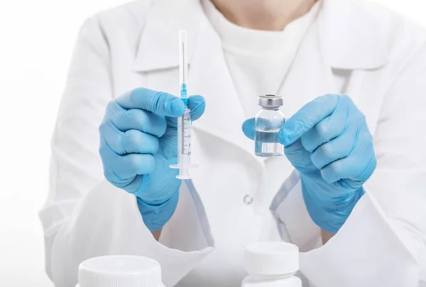 Doktor elinde ilaç şişesi tutuyor.