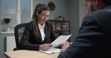 Lady in formal clothing reading resume of new employee