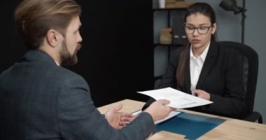 Confident man giving resume to female hr manager