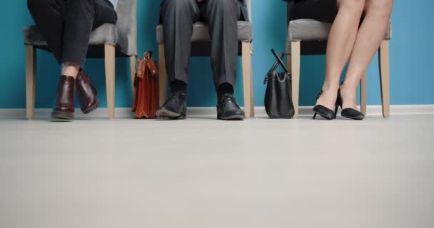 Primer plano de las piernas de los solicitantes a la espera de entrevista de trabajo — Vídeos de Stock