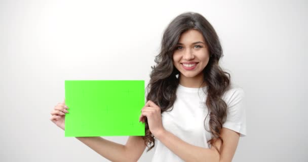 Mujer sosteniendo verde marcado en blanco aislado en blanco — Vídeos de Stock