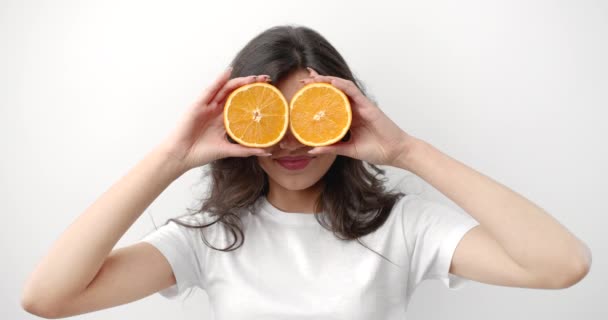 Mujer con rebanadas naranja divertirse aislado en blanco — Vídeos de Stock