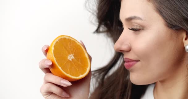 Donna che odora di arancia affettata isolata su bianco — Video Stock