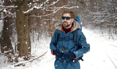 Hiker walking in winter forest