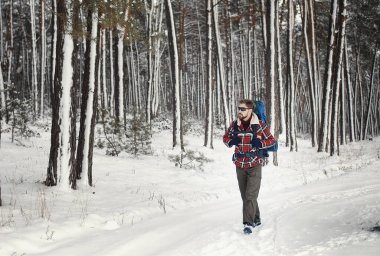 Backpacker walking snowy forest trial