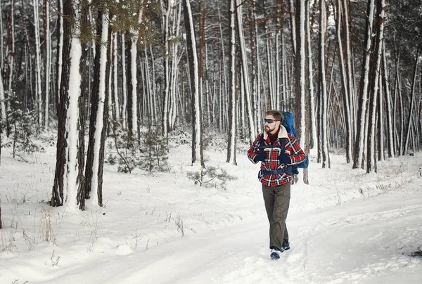 Backpacker walking snowy forest trial — Zdjęcie stockowe