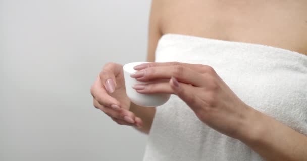 Primer plano del frasco de crema blanca en manos femeninas — Vídeos de Stock