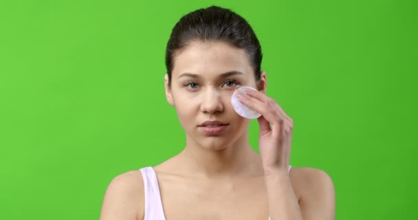 Beautiful young girl using cotton pad for removing makeup — Stock Video