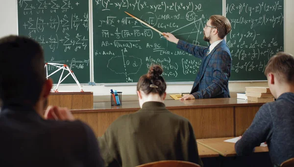 Вчитель математики, що вказує на крейдяну дошку — стокове фото