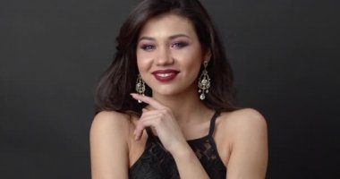 Gorgeous girl with curly hair and bright makeup in studio
