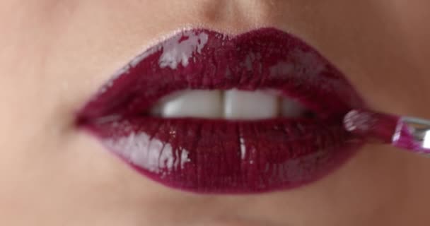 Extreme close up of female model applying marsala lipstick — Stok video