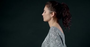 Koyu arkaplanda güzel bir kızın yan görüntüsü