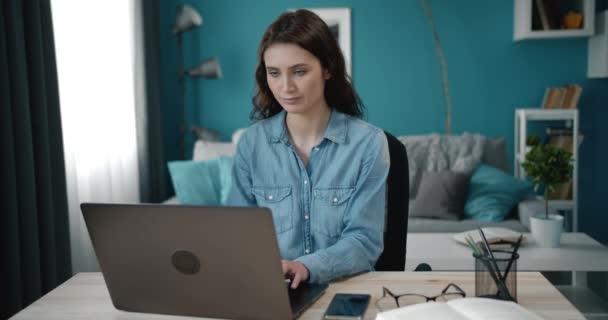 집약 된 젊은 여자 가집에서 노트북으로 일하고 있다 — 비디오