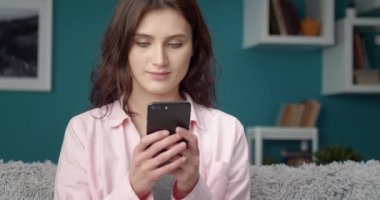 Gülümseyen kadın arkadaşlarıyla sohbet etmek için akıllı telefon kullanıyor.