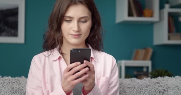 Glimlachende vrouw die smartphone gebruikt om met vrienden te chatten — Stockvideo