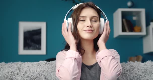 Portrait of charming girl enjoying music on headphones — Stock Video