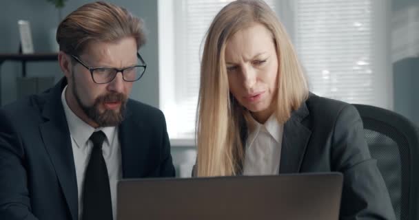 Grupo de dos gerentes de oficina trabajando juntos en el ordenador portátil — Vídeo de stock