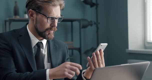 Успешный бородатый мужчина с помощью смартфона на рабочем месте — стоковое видео
